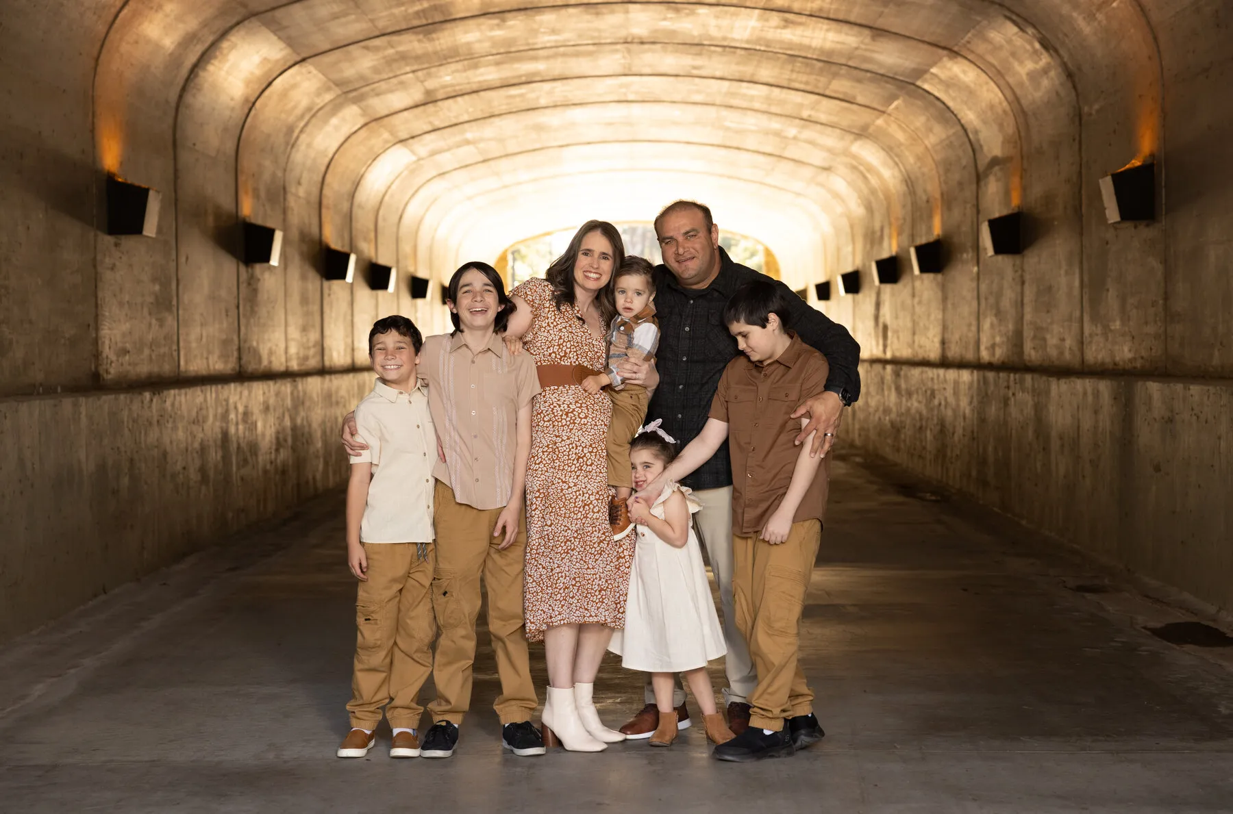 Rod and his wife with their five children under the arched underpass at Lago Santa Margarita, late afternoon light down the tunnel behind them.